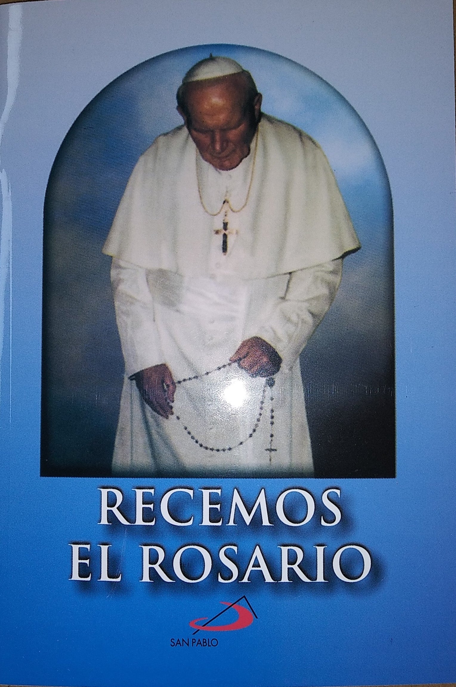 Book cover with a portrait of a religious figure holding a rosary and text 'Recemos El Rosario' on a blue background.
